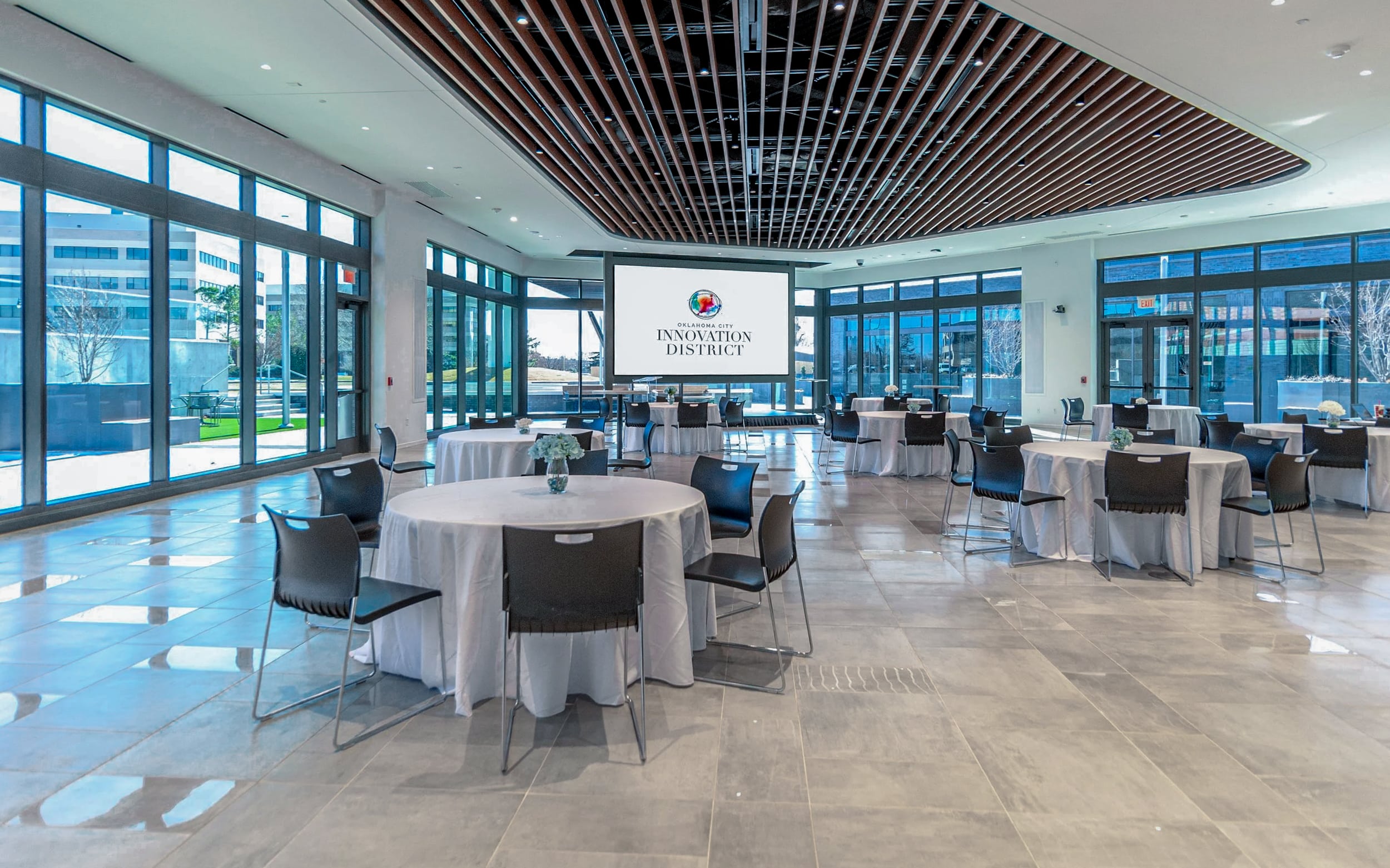 Innovation Hall event space arranged with round banquet tables facing a large presentation screen.