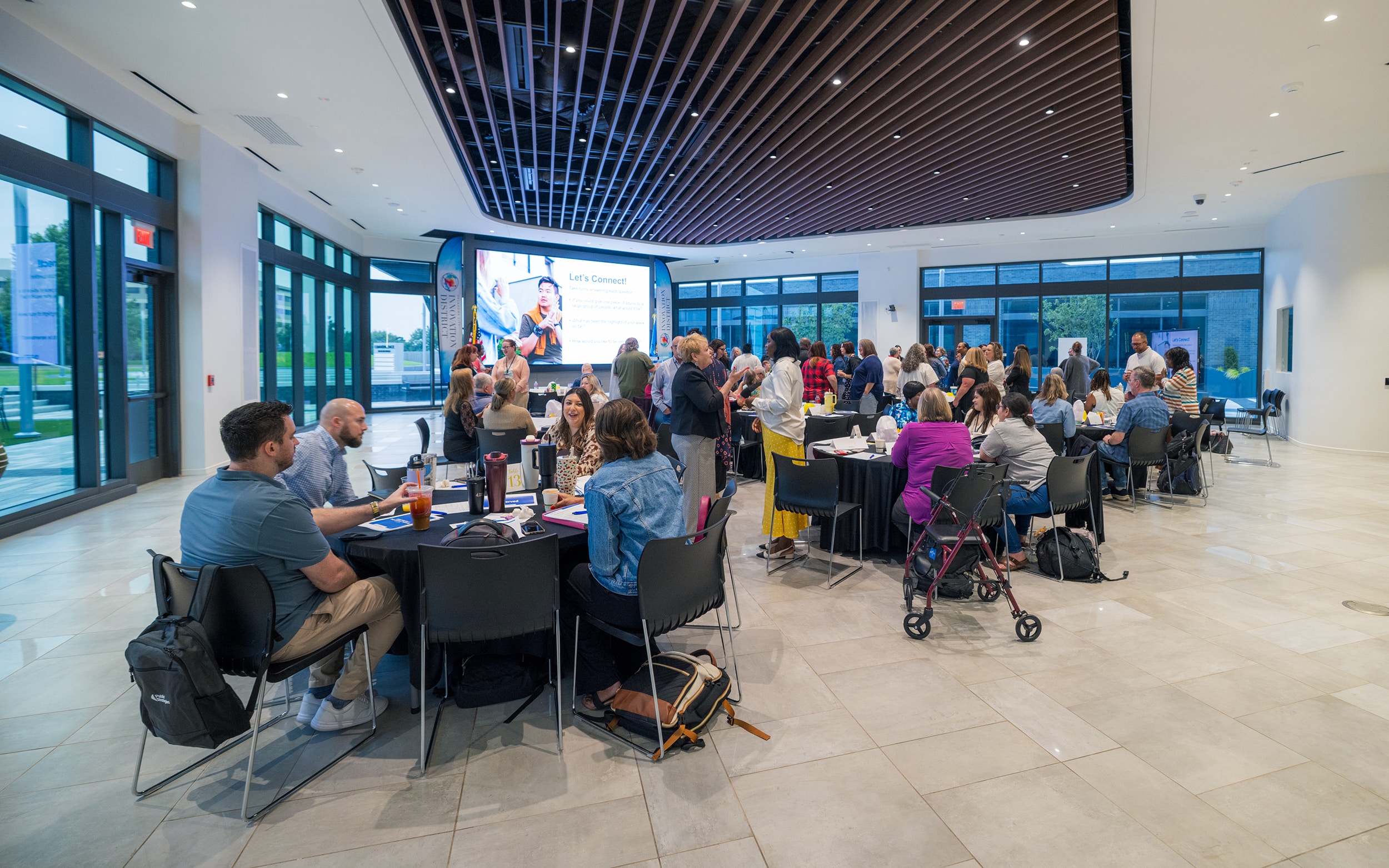 Guests seated around banquet tables for a presentation inside Innovation Hall.